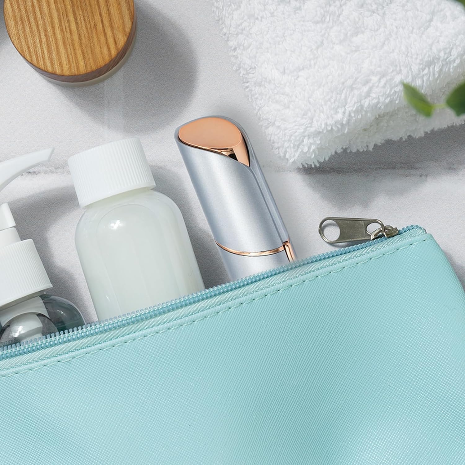 INNOBEAUT facial hair remover stored inside a light blue travel pouch with skincare bottles and a towel, highlighting its compact and portable design.